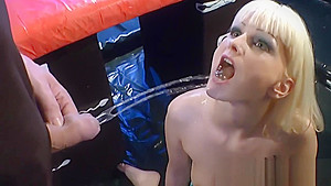 Blonde is on her knees while group of men surround and piss on her
