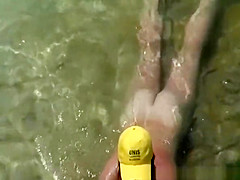 Mature nudist with yellow hat on her head